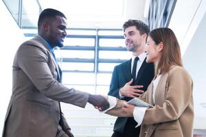 Business people shaking hands. finishing up a meeting. team of business people walk in rush hour at indoor pedestrian stairs and talk together. concept negotiations in feeling successful and happy. photo