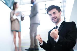 business people and office concept. happy smiling businessman in dark suit. Portrait of smiling mid adult businessman standing at corporate office. Businessman smiling with arms crossed in office. photo