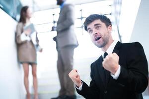 business people and office concept. happy smiling businessman in dark suit. Portrait of smiling mid adult businessman standing at corporate office. Businessman smiling with arms crossed in office. photo