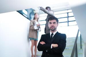 negocio personas y oficina concepto. contento sonriente empresario en oscuro traje. retrato de sonriente medio adulto empresario en pie a corporativo oficina. empresario sonriente con brazos cruzado en oficina. foto