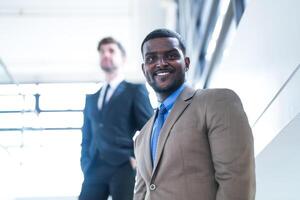 business people and office concept. happy smiling businessman in dark suit. Portrait of smiling mid adult businessman standing at corporate office. Businessman smiling with arms crossed in office. photo