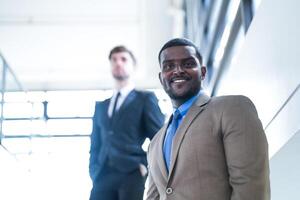 business people and office concept. happy smiling businessman in dark suit. Portrait of smiling mid adult businessman standing at corporate office. Businessman smiling with arms crossed in office. photo