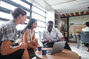 Diverse employees gathered in office having fun during brainstorming while discussing new ideas project. Multiracial coworkers meeting at coworking space area. team of young people in office. photo