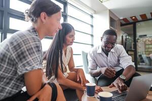 Diverse employees gathered in office having fun during brainstorming while discussing new ideas project. Multiracial coworkers meeting at coworking space area. team of young people in office. photo