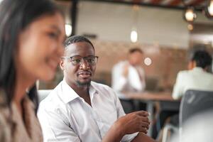 focus of smart african businessman. Diverse employees gathered in office having fun brainstorming while discussing new ideas project. Multiracial coworkers meeting at coworking space area. photo