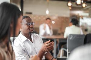 focus of smart african businessman. Diverse employees gathered in office having fun brainstorming while discussing new ideas project. Multiracial coworkers meeting at coworking space area. photo