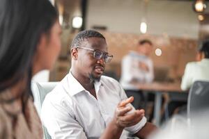 focus of smart african businessman. Diverse employees gathered in office having fun brainstorming while discussing new ideas project. Multiracial coworkers meeting at coworking space area. photo