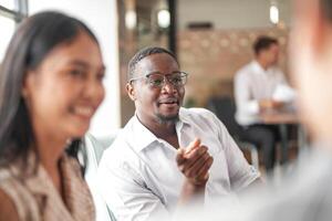 focus of smart african businessman. Diverse employees gathered in office having fun brainstorming while discussing new ideas project. Multiracial coworkers meeting at coworking space area. photo