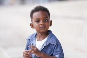 Mixed race African and Asian boy is playing at the outdoor area. smiling happy boy has fun running on the beach. portrait of boy lifestyle with a unique hairstyle. photo