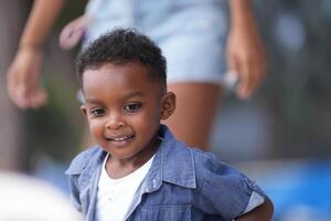 Mixed race African and Asian boy is playing at the outdoor area. smiling happy boy has fun running on the beach. portrait of boy lifestyle with a unique hairstyle. photo