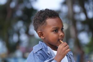 Mixed race African and Asian boy is playing at the outdoor area. smiling happy boy has fun running on the beach. portrait of boy lifestyle with a unique hairstyle. photo