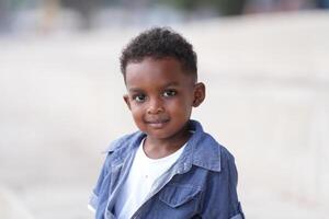 Mixed race African and Asian boy is playing at the outdoor area. smiling happy boy has fun running on the beach. portrait of boy lifestyle with a unique hairstyle. photo