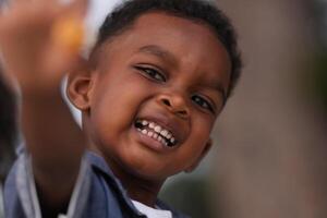 Mixed race African and Asian boy is playing at the outdoor area. smiling happy boy has fun running on the beach. portrait of boy lifestyle with a unique hairstyle. photo