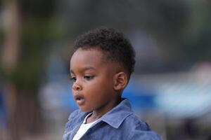 Mixed race African and Asian boy is playing at the outdoor area. smiling happy boy has fun running on the beach. portrait of boy lifestyle with a unique hairstyle. photo