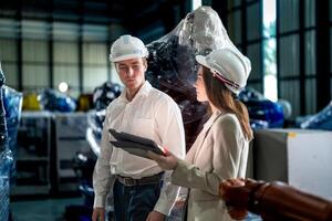 negocio ingenieros reunión y comprobación nuevo máquina robot. trabajadores caminando a almacén industria soldadura máquina. negocio negociación conceptos y tecnología. mujer utilizando inteligente tableta a presente hombre. foto