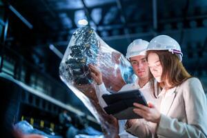 Sales manager and factory owner in suits negotiating selling robots used in the factory. Business engineers meeting and checking new machine robot. Workers walking at warehouse welding machine. photo