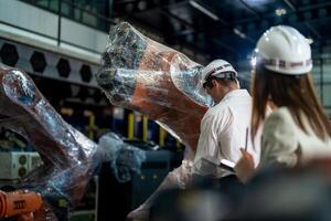 negocio ingenieros reunión y comprobación nuevo máquina robot. trabajadores caminando a almacén industria soldadura máquina. negocio negociación conceptos y tecnología. mujer utilizando inteligente tableta a presente hombre. foto