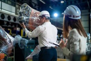 Business engineers meeting and checking new machine robot. Workers walking at warehouse industry welding machine. business negotiation concepts and technology. women Using smart Tablet to present man. photo