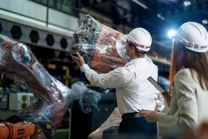 negocio ingenieros reunión y comprobación nuevo máquina robot. trabajadores caminando a almacén industria soldadura máquina. negocio negociación conceptos y tecnología. mujer utilizando inteligente tableta a presente hombre. foto