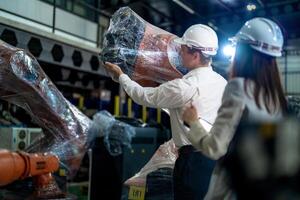 negocio ingenieros reunión y comprobación nuevo máquina robot. trabajadores caminando a almacén industria soldadura máquina. negocio negociación conceptos y tecnología. mujer utilizando inteligente tableta a presente hombre. foto