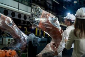 negocio ingenieros reunión y comprobación nuevo máquina robot. trabajadores caminando a almacén industria soldadura máquina. negocio negociación conceptos y tecnología. mujer utilizando inteligente tableta a presente hombre. foto