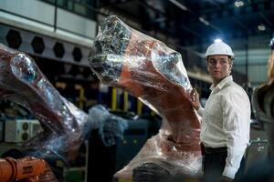 negocio ingenieros reunión y comprobación nuevo máquina robot. trabajadores caminando a almacén industria soldadura máquina. negocio negociación conceptos y tecnología. mujer utilizando inteligente tableta a presente hombre. foto