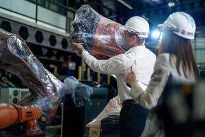 negocio ingenieros reunión y comprobación nuevo máquina robot. trabajadores caminando a almacén industria soldadura máquina. negocio negociación conceptos y tecnología. mujer utilizando inteligente tableta a presente hombre. foto