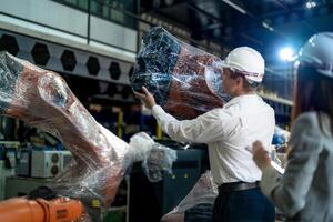 negocio ingenieros reunión y comprobación nuevo máquina robot. trabajadores caminando a almacén industria soldadura máquina. negocio negociación conceptos y tecnología. mujer utilizando inteligente tableta a presente hombre. foto