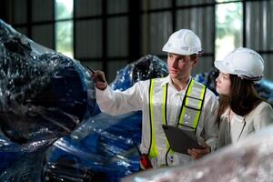 Factory engineers inspecting on machine with smart tablet. Worker works at machine robot arm. The welding machine with a remote system in an industrial factory. Artificial intelligence concept. photo