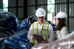 Factory engineers inspecting on machine with smart tablet. Worker works at machine robot arm. The welding machine with a remote system in an industrial factory. Artificial intelligence concept. photo