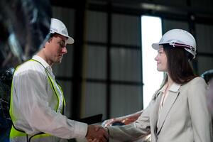 Sales manager and factory owner in suits negotiating selling robots used in the factory. Business engineers meeting and checking new machine robot. Workers walking at warehouse welding machine. photo