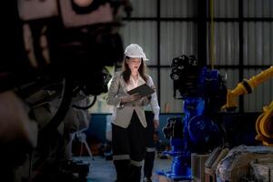 negocio mujer y hombre reunión y comprobación nuevo máquina robot. ingeniero caminando a almacén industria máquina. negocio negociación conceptos y tecnología. mujer es utilizando inteligente tableta a presente hombre. foto