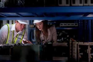 comprobación y inspeccionando metal máquina parte artículos para envío. masculino y mujer trabajador comprobación el Tienda fábrica. industria fábrica depósito. el almacén de de repuesto parte para maquinaria y vehículos foto