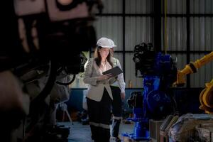 negocio mujer y hombre reunión y comprobación nuevo máquina robot. ingeniero caminando a almacén industria máquina. negocio negociación conceptos y tecnología. mujer es utilizando inteligente tableta a presente hombre. foto