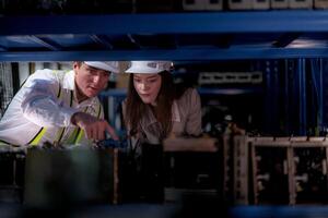 comprobación y inspeccionando metal máquina parte artículos para envío. masculino y mujer trabajador comprobación el Tienda fábrica. industria fábrica depósito. el almacén de de repuesto parte para maquinaria y vehículos foto