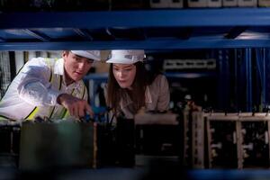 comprobación y inspeccionando metal máquina parte artículos para envío. masculino y mujer trabajador comprobación el Tienda fábrica. industria fábrica depósito. el almacén de de repuesto parte para maquinaria y vehículos foto