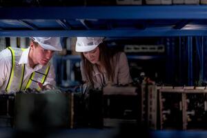 técnico ingenieros equipo comprobación el máquina y mantenimiento servicio. trabajadores mirando a de repuesto partes en valores a almacén fábrica. obrero con un Lista de Verificación mirando en parte de máquina partes. foto