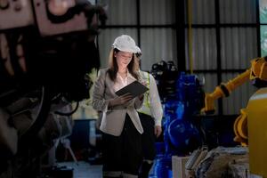 negocio mujer y hombre reunión y comprobación nuevo máquina robot. ingeniero caminando a almacén industria máquina. negocio negociación conceptos y tecnología. mujer es utilizando inteligente tableta a presente hombre. foto