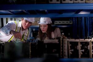 checking and inspecting metal machine part items for shipping. male and woman worker checking the store factory. industry factory warehouse. The warehouse of spare part for machinery and vehicles. photo