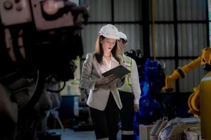 negocio mujer y hombre reunión y comprobación nuevo máquina robot. ingeniero caminando a almacén industria máquina. negocio negociación conceptos y tecnología. mujer es utilizando inteligente tableta a presente hombre. foto