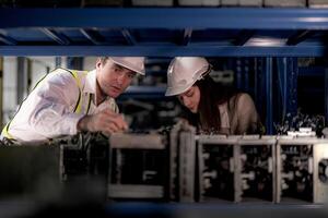 técnico ingenieros equipo comprobación el máquina y mantenimiento servicio. trabajadores mirando a de repuesto partes en valores a almacén fábrica. obrero con un Lista de Verificación mirando en parte de máquina partes. foto