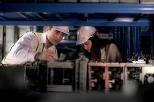 comprobación y inspeccionando metal máquina parte artículos para envío. masculino y mujer trabajador comprobación el Tienda fábrica. industria fábrica depósito. el almacén de de repuesto parte para maquinaria y vehículos foto