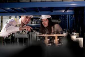 checking and inspecting metal machine part items for shipping. male and woman worker checking the store factory. industry factory warehouse. The warehouse of spare part for machinery and vehicles. photo