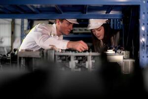 technician engineers team checking the machine and maintenance service. workers looking at spare parts in stock at warehouse factory. laborer with a checklist looking on part of machine parts. photo