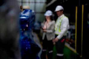 negocio mujer y hombre reunión y comprobación nuevo máquina robot. ingeniero caminando a almacén industria máquina. negocio negociación conceptos y tecnología. mujer es utilizando inteligente tableta a presente hombre. foto