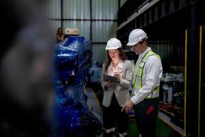 negocio mujer y hombre reunión y comprobación nuevo máquina robot. ingeniero caminando a almacén industria máquina. negocio negociación conceptos y tecnología. mujer es utilizando inteligente tableta a presente hombre. foto