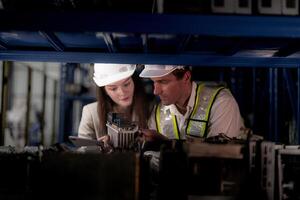 técnico ingenieros equipo comprobación el máquina y mantenimiento servicio. trabajadores mirando a de repuesto partes en valores a almacén fábrica. obrero con un Lista de Verificación mirando en parte de máquina partes. foto