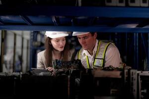 checking and inspecting metal machine part items for shipping. male and woman worker checking the store factory. industry factory warehouse. The warehouse of spare part for machinery and vehicles. photo