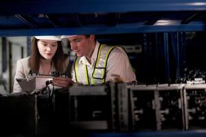 checking and inspecting metal machine part items for shipping. male and woman worker checking the store factory. industry factory warehouse. The warehouse of spare part for machinery and vehicles. photo