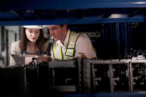 comprobación y inspeccionando metal máquina parte artículos para envío. masculino y mujer trabajador comprobación el Tienda fábrica. industria fábrica depósito. el almacén de de repuesto parte para maquinaria y vehículos foto